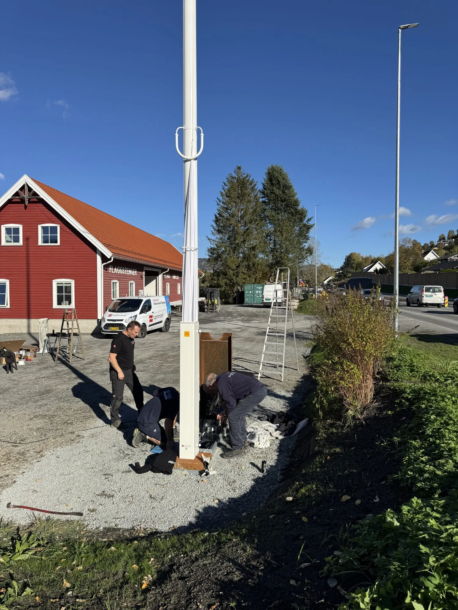 Montører reiser den hvite Uptimast-flaggstangen på teknikkassen